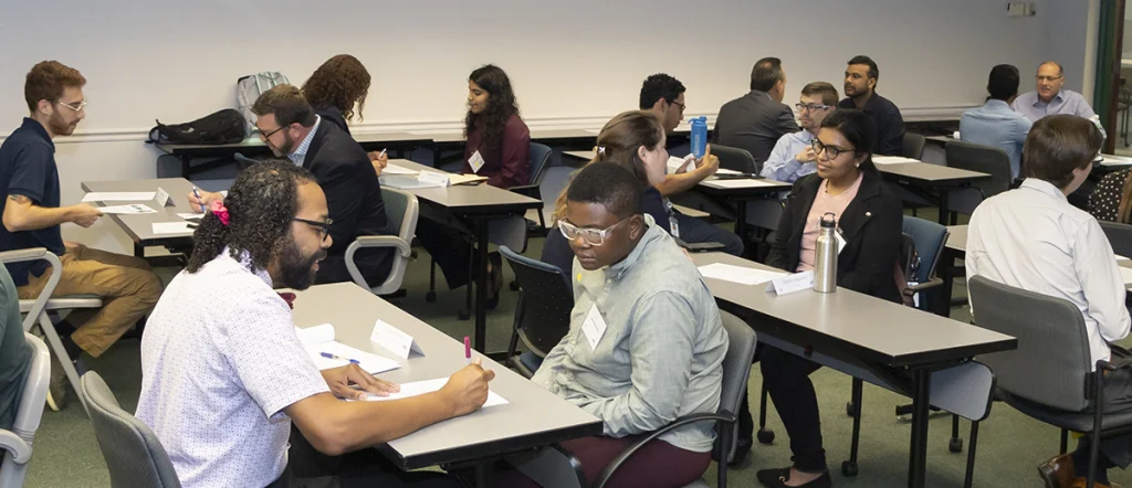 Classroom lined up with tables where students are being interviewed by interviewers.