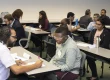 Classroom lined up with tables where students are being interviewed by interviewers.