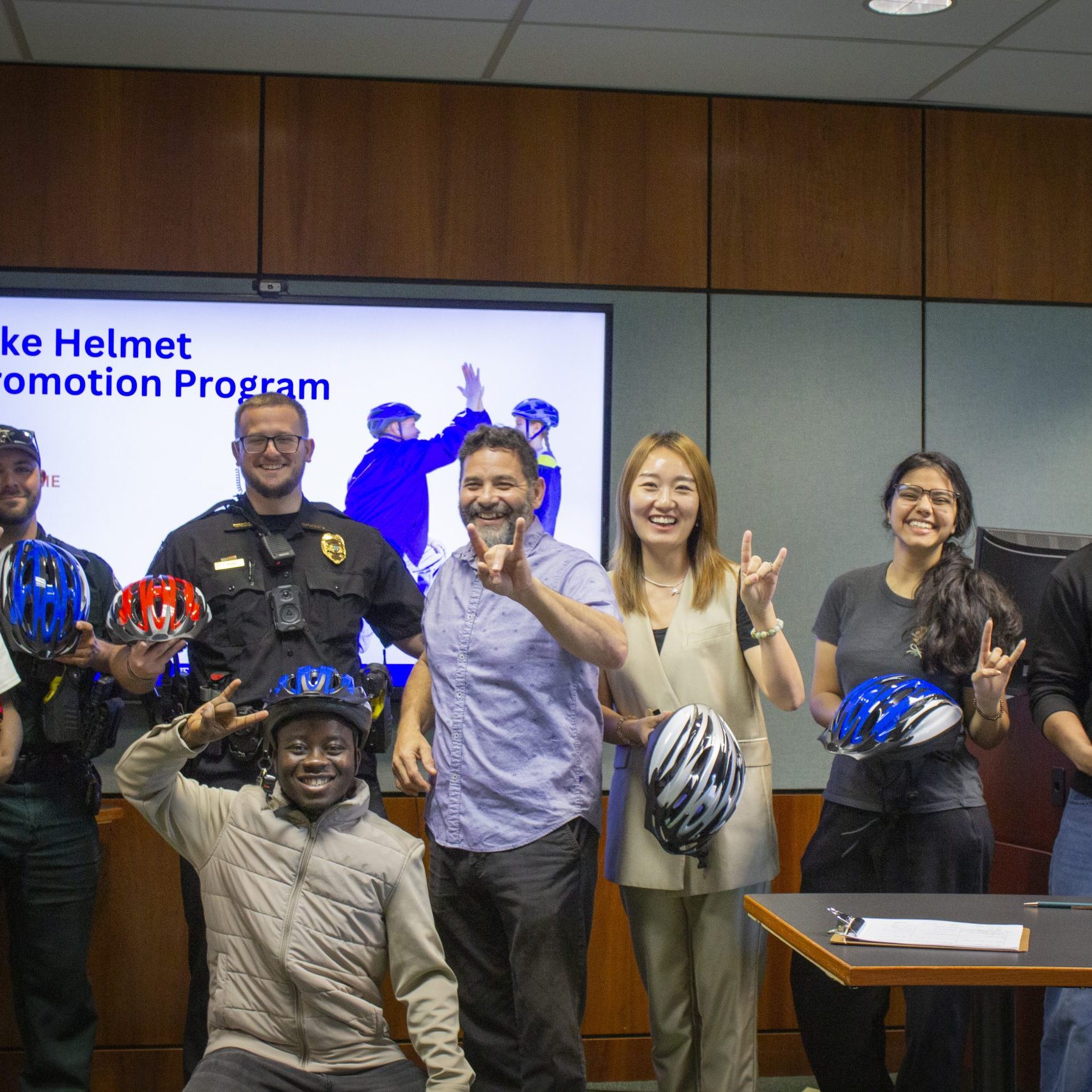 smiling group stands together making the 'bulls' hand gesture
