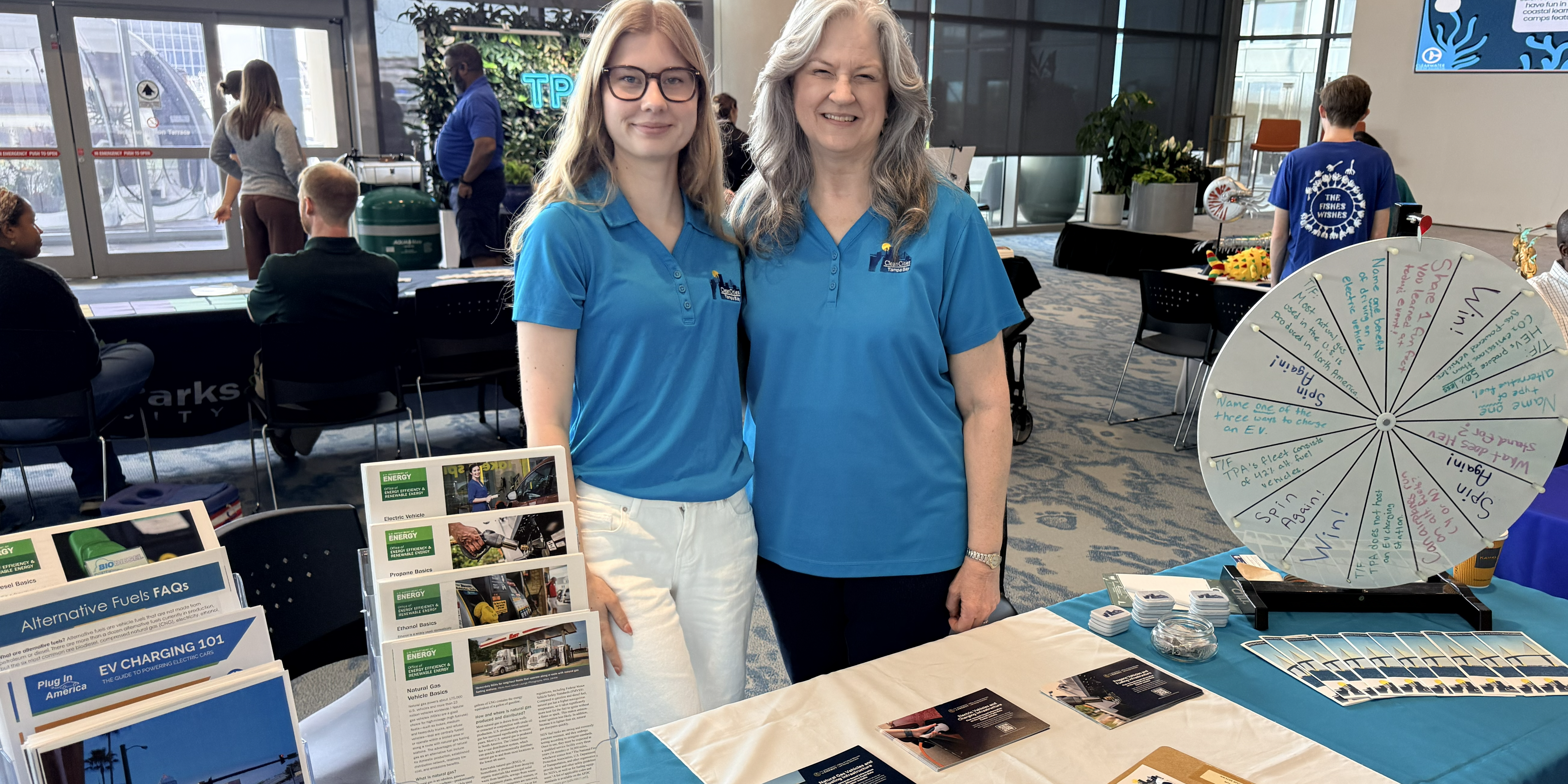 Jana and Kiley_photo by Beau Zimmer Two women stand next to exhibitor table displaying informational materials.