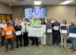 diverse group of adults stand together for a group photo holding their training certificates